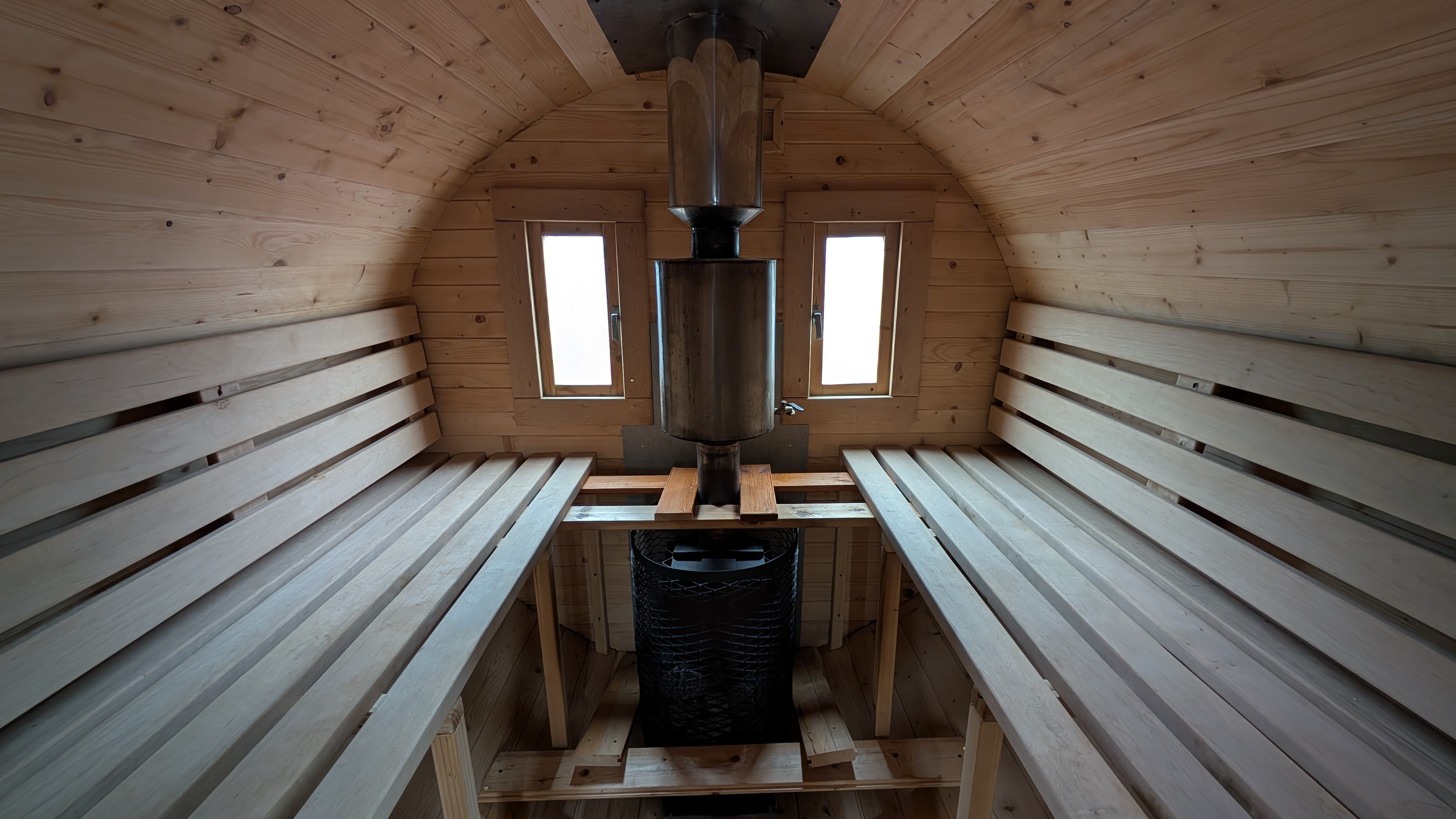 Barrel sauna interior with benches and stove